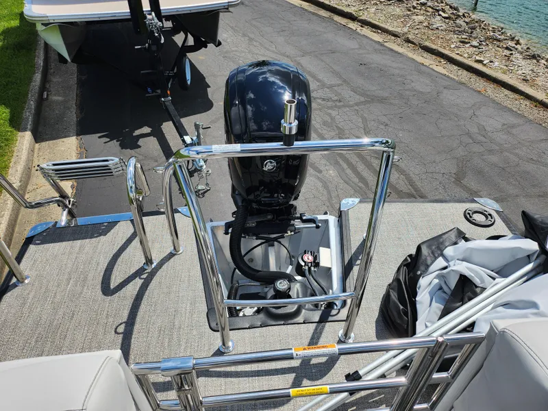Slide: The Image of 2021 Barletta CORSA 23QC boat with outboard motor, docked near a lakeside. - 17