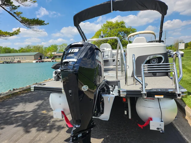 Slide: The Image of 2021 Barletta CORSA 23QC pontoon boat with outboard motor, docked by a scenic lake. - 2