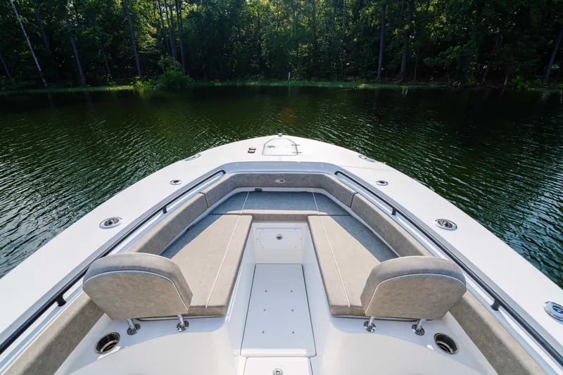 Slide: The Image of 2026 Sea Hunt Gamefish 25 boat interior with cushioned seating on a calm lake. - 3