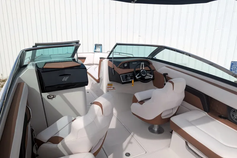 Slide: The Image of 2017 Four Winns HD240 OB boat interior with white and brown seating, steering wheel, and dashboard. - 10