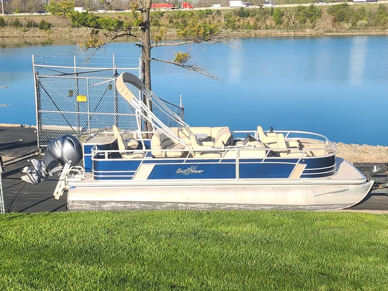 The Image of 2018 SunChaser Geneva Cruise 22 DLX 4.0 Fish pontoon boat docked by a serene lake. - 0