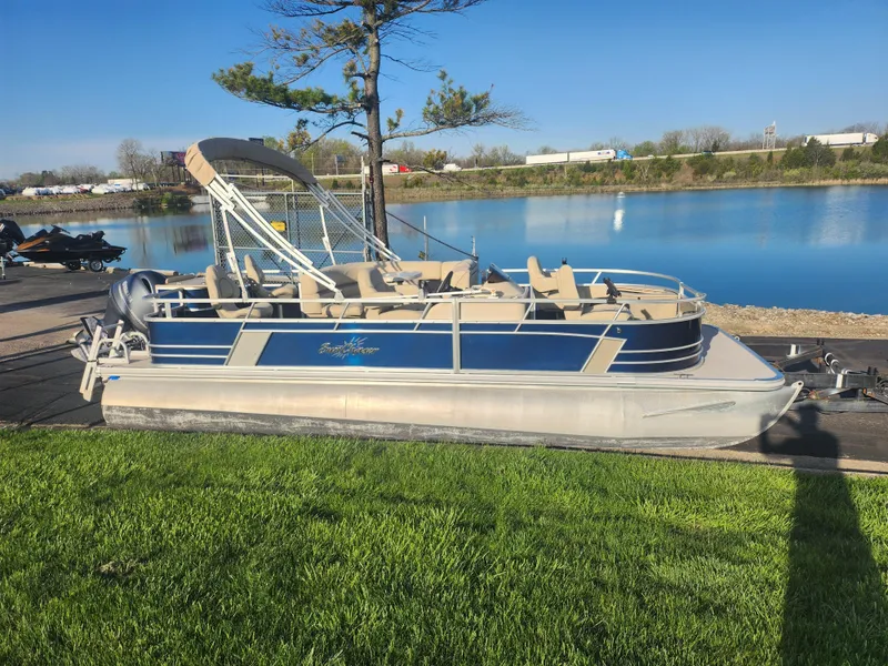 Slide: The Image of 2018 SunChaser Geneva Cruise 22 DLX 4.0 Fish pontoon boat by a serene lake. - 9