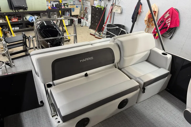 Slide: The Image of 2026 Harris Cruiser 210 boat interior with white seating in a workshop setting. - 9