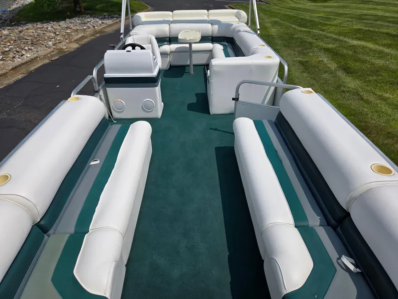 Slide: The Image of 2000 Odyssey Pontoons 2505 Millennium with spacious seating and green carpet on a sunny day. - 10
