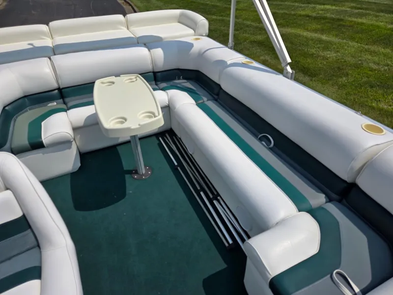 Slide: The Image of 2000 Odyssey Pontoons 2505 Millennium interior with white and green seating, table, and cup holders. - 15