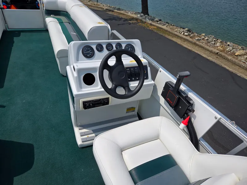 Slide: The Image of 2000 Odyssey Pontoons 2505 Millennium boat interior with steering wheel and seating. - 21