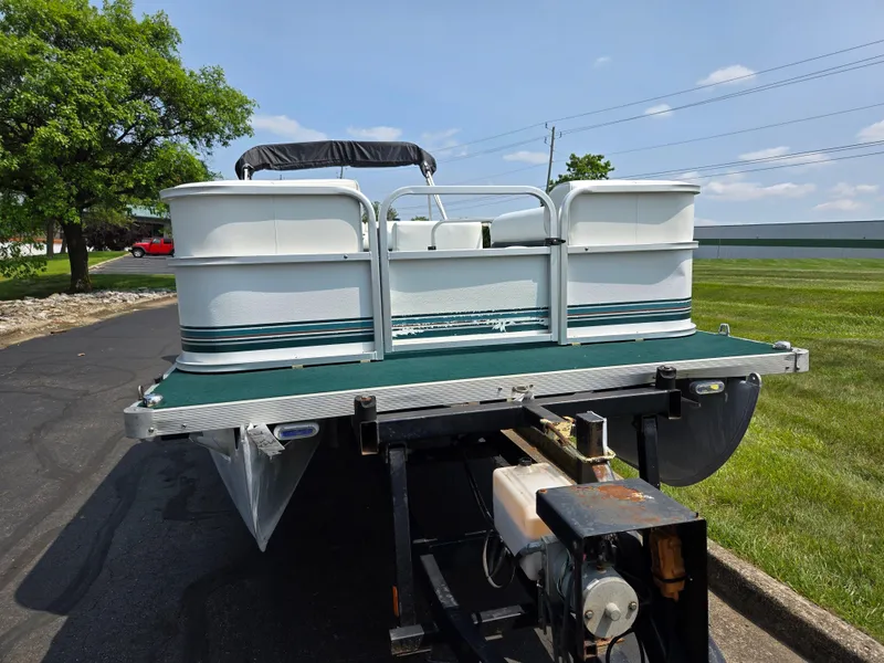 Slide: The Image of 2000 Odyssey Pontoons 2505 Millennium on trailer, parked on a sunny day. - 6