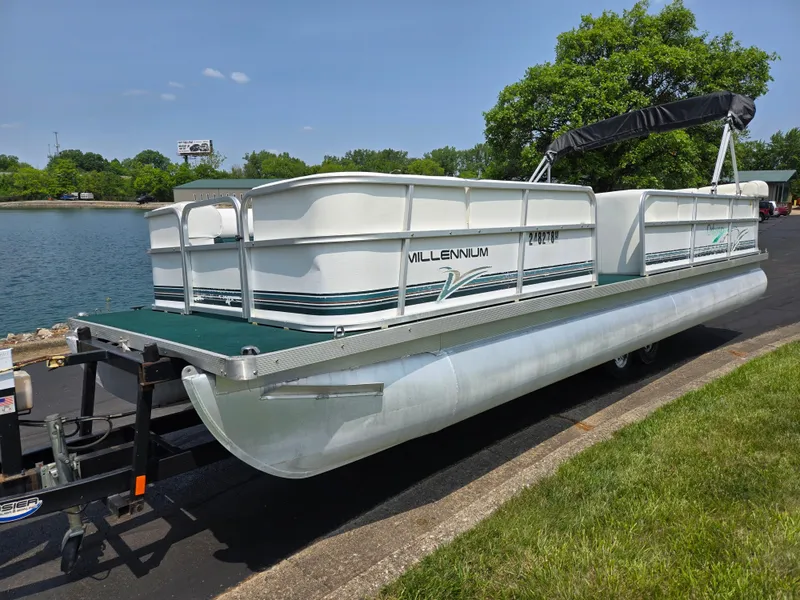 Slide: The Image of 2000 Odyssey Pontoons 2505 Millennium boat on trailer by a lake. - 8