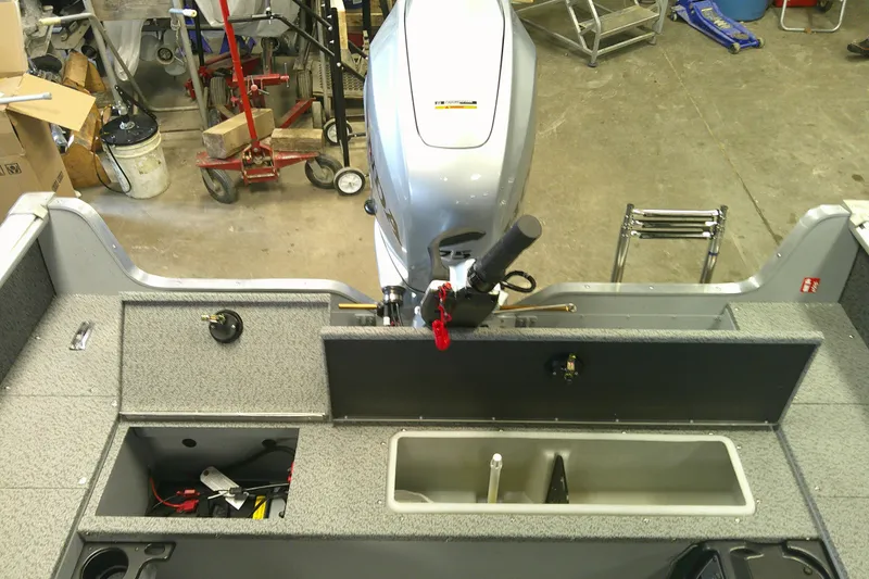 Slide: The Image of 2026 Lund 1700 Explorer Tiller boat interior with motor and storage compartments. - 11