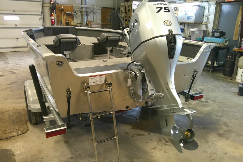 Slide: The Image of 2026 Lund 1700 Explorer Tiller boat with Honda 75 engine in a workshop. - 4