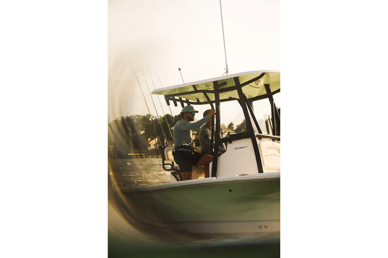 Slide: The Image of Man steering 2026 Sea Hunt BX 22 BR boat on water at sunset. - 4