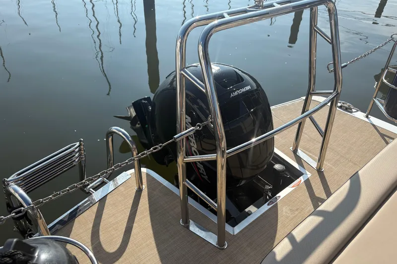 Slide: The Image of 2024 Harris HCX23 boat with Mercury outboard motor, docked on calm water. - 5