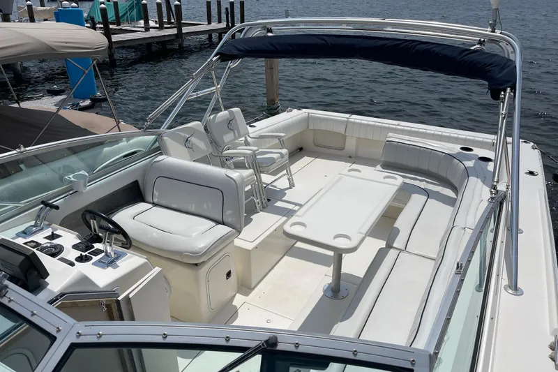 Slide: The Image of 1994 Sea Ray 310 Amberjack boat with spacious seating and helm, docked by the water. - 11