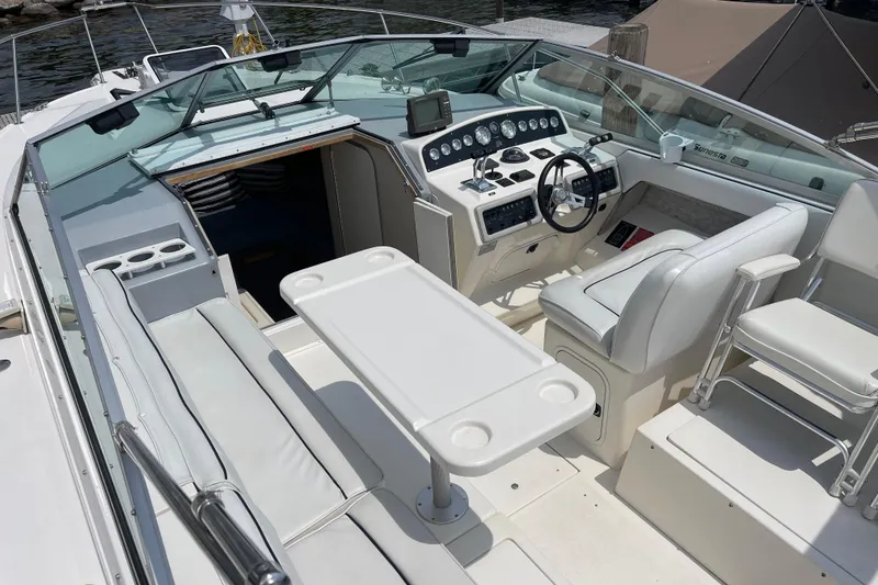 Slide: The Image of 1994 Sea Ray 310 Amberjack boat interior with helm, seating, and table setup. - 13