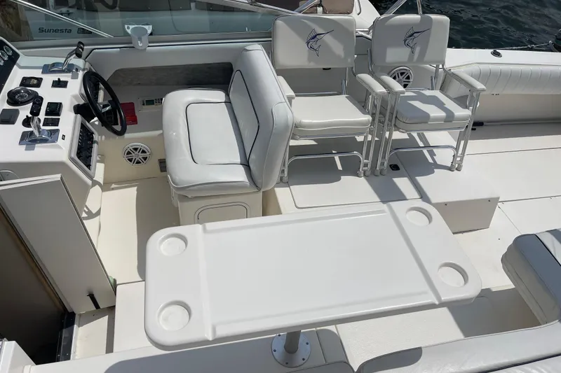 Slide: The Image of 1994 Sea Ray 310 Amberjack boat interior with helm, seating, and table setup. - 14