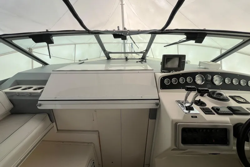 Slide: The Image of 1994 Sea Ray 310 Amberjack boat cockpit with steering controls and navigation instruments. - 21