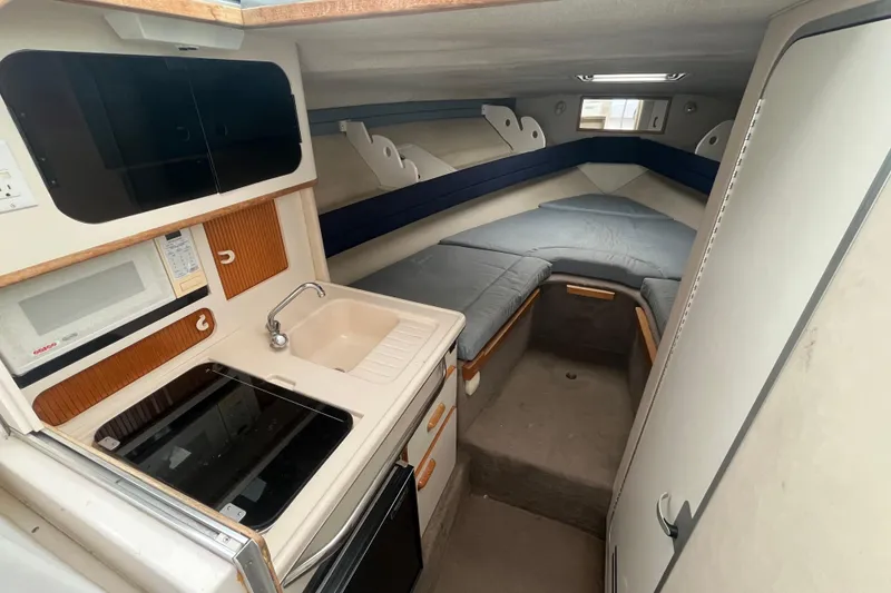 Slide: The Image of 1994 Sea Ray 310 Amberjack cabin interior with kitchenette and sleeping area. - 27