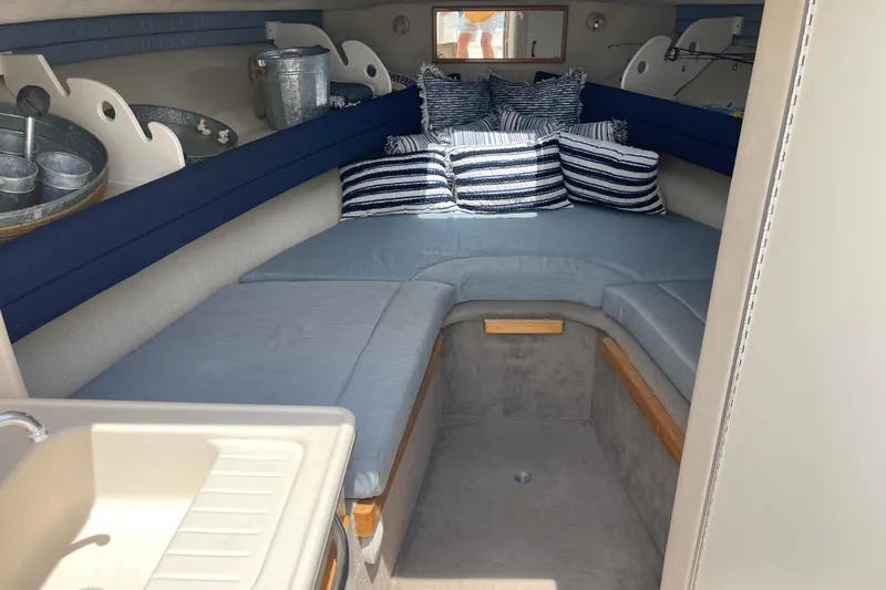 Slide: The Image of Cozy interior of 1994 Sea Ray 310 Amberjack with striped pillows and seating. - 28