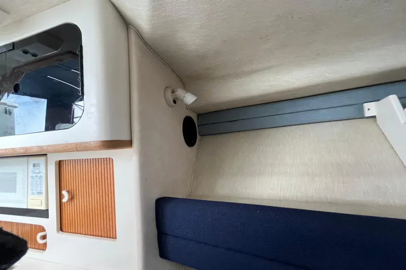 Slide: The Image of Interior of a 1994 Sea Ray 310 Amberjack boat, featuring cabinetry and seating. - 29