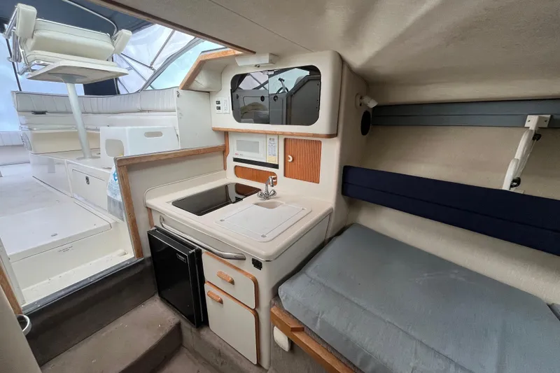 Slide: The Image of Interior of 1994 Sea Ray 310 Amberjack boat with kitchenette and seating area. - 32