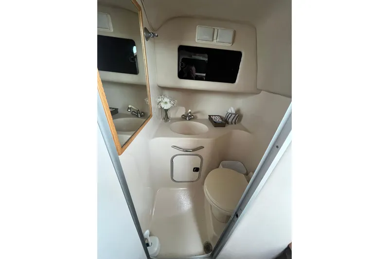 Slide: The Image of 1994 Sea Ray 310 Amberjack bathroom with sink, mirror, and toilet. - 33