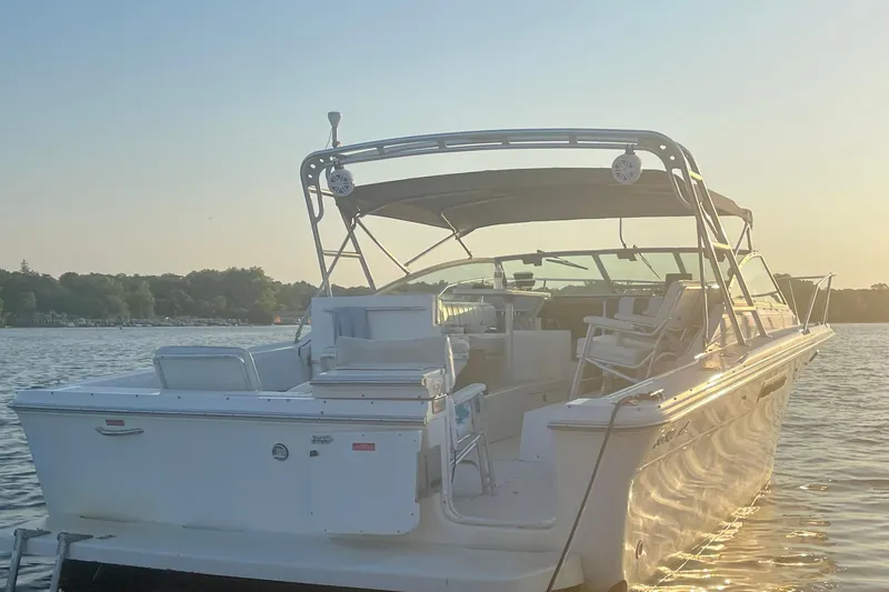 Slide: The Image of 1994 Sea Ray 310 Amberjack boat on calm water at sunset. - 4