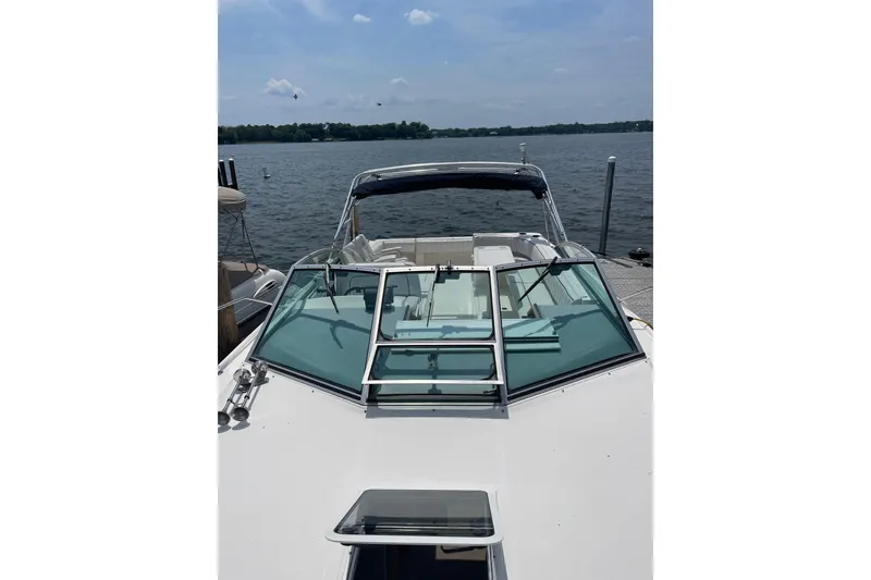 Slide: The Image of 1994 Sea Ray 310 Amberjack boat docked on a sunny lake. - 9