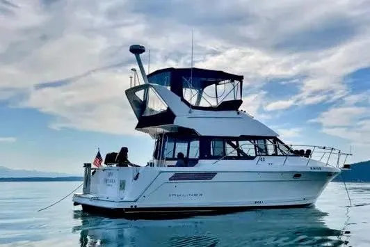 Slide: The Image of 1992 Bayliner 3688 Motoryacht on calm water under a partly cloudy sky. - 1