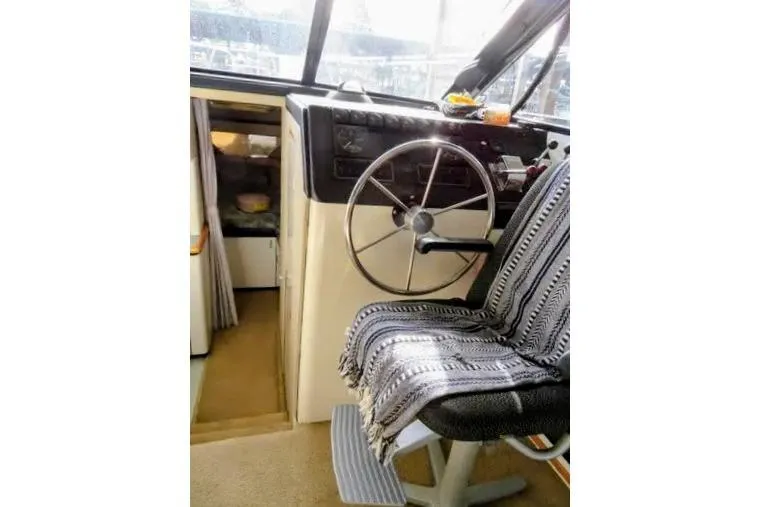 Slide: The Image of 1992 Bayliner 3688 Motoryacht helm with striped seat cover and steering wheel. - 17