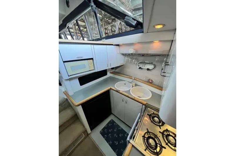 Slide: The Image of 1992 Bayliner 3688 Motoryacht kitchen with stove, sink, microwave, and cabinetry. - 20