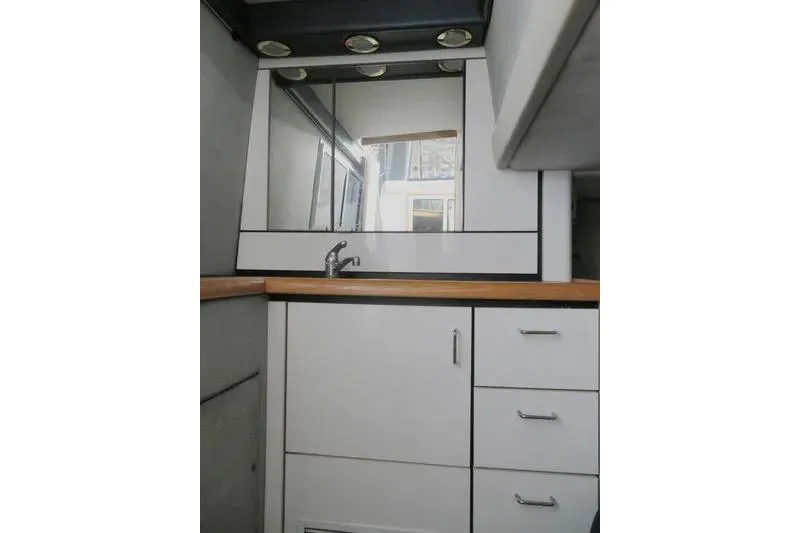 Slide: The Image of 1992 Bayliner 3688 Motoryacht bathroom with mirror, sink, and storage cabinets. - 25