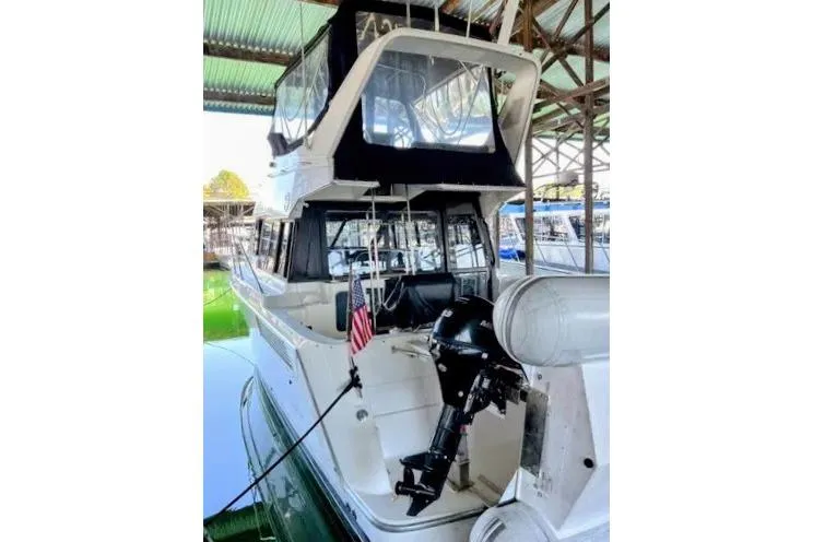 Slide: The Image of 1992 Bayliner 3688 Motoryacht docked under a covered marina. - 3