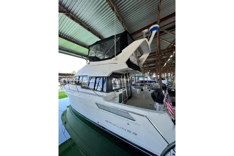 Slide: The Image of 1992 Bayliner 3688 Motoryacht docked under a metal roof. - 4