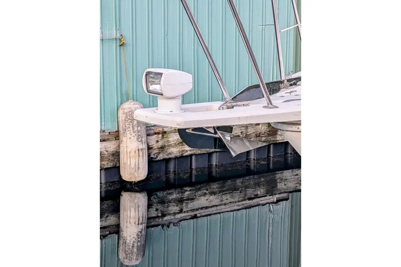 Slide: The Image of 1992 Bayliner 3688 Motoryacht bow with anchor and spotlight, docked by a teal wall. - 6
