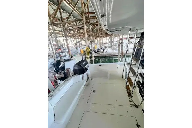 Slide: The Image of 1992 Bayliner 3688 Motoryacht docked in a marina, showcasing spacious deck and seating area. - 7