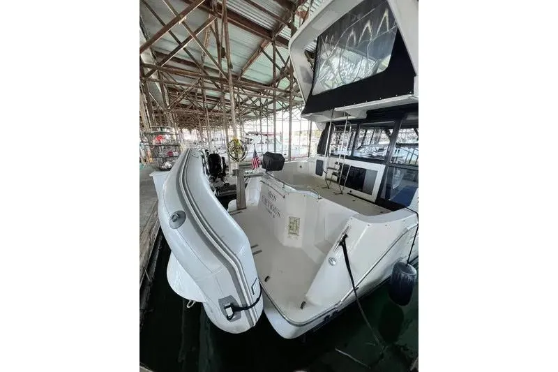 Slide: The Image of 1992 Bayliner 3688 Motoryacht docked in a covered marina, rear view. - 9