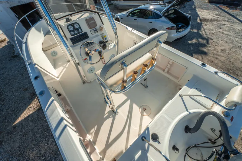 Slide: The Image of Century 2001 model boat interior with steering console, parked near a car. - 15