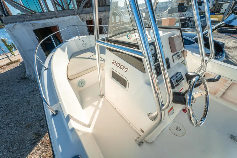 Slide: The Image of Century 2001 model boat interior with steering wheel and control panel, docked outdoors. - 22
