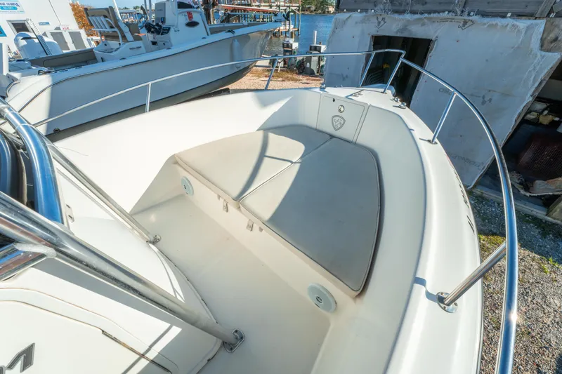 Slide: The Image of Bow seating area of a 2006 Century 2001 model boat, docked near water. - 24