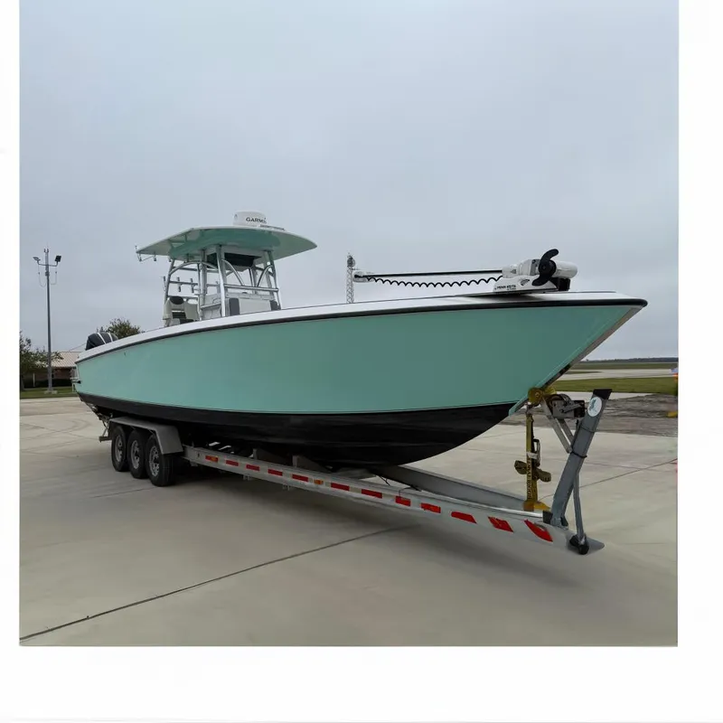 Slide: The Image of 2008 Contender 36 Open boat on trailer, light blue hull, overcast sky. - 0