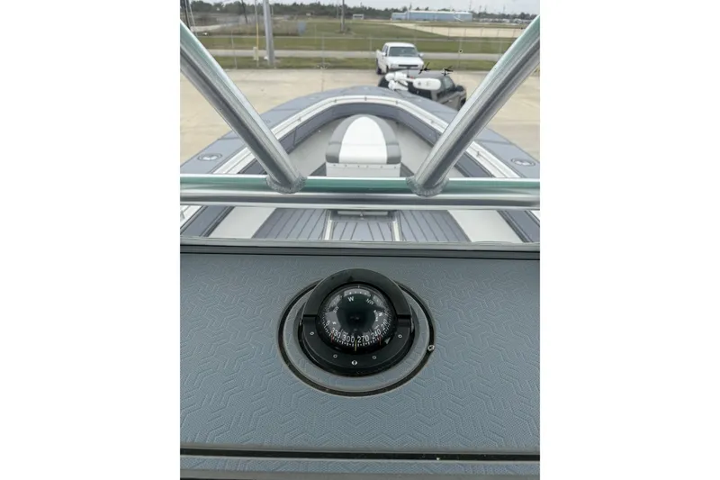 Slide: The Image of 2008 Contender 36 Open boat dashboard with compass, view of bow and parked vehicles. - 25