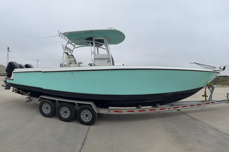 Slide: The Image of 2008 Contender 36 Open boat on trailer, light blue hull, triple-axle trailer. - 4