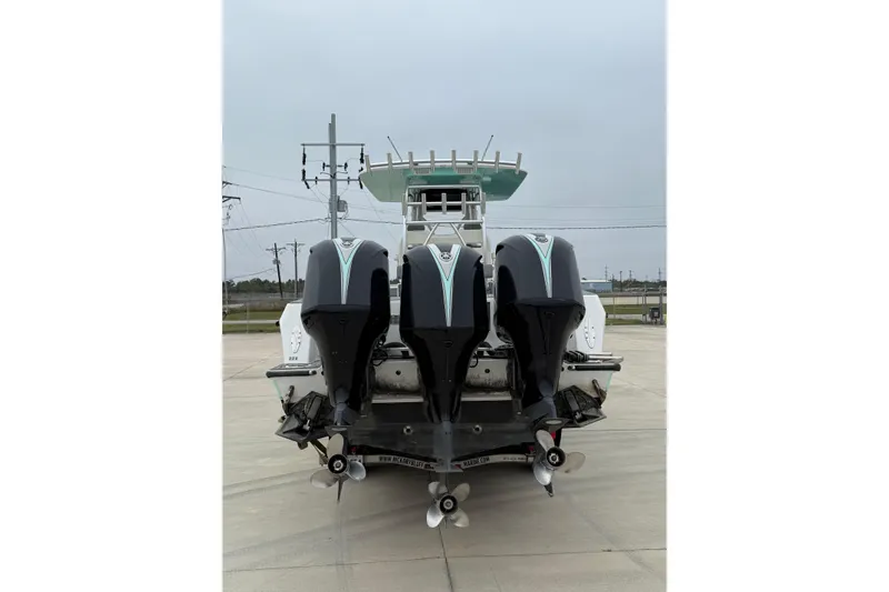 Slide: The Image of 2008 Contender 36 Open boat with triple outboard engines, rear view on concrete surface. - 8