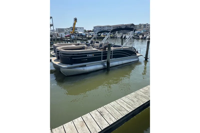 The Image of 2024 Harris HCX23 pontoon boat docked in a marina, sunny day. - 1
