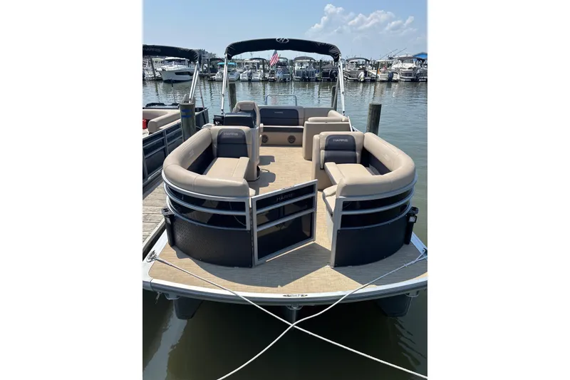Slide: The Image of 2024 Harris HCX23 pontoon boat docked, featuring spacious seating and sleek design. - 3