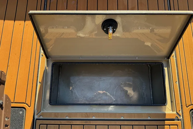 Slide: The Image of Open storage compartment on 2026 SeaArk Big Easy boat with wooden deck. - 11