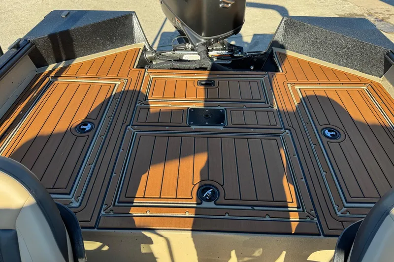 Slide: The Image of 2026 SeaArk Big Easy boat deck with wood finish and storage compartments. - 15