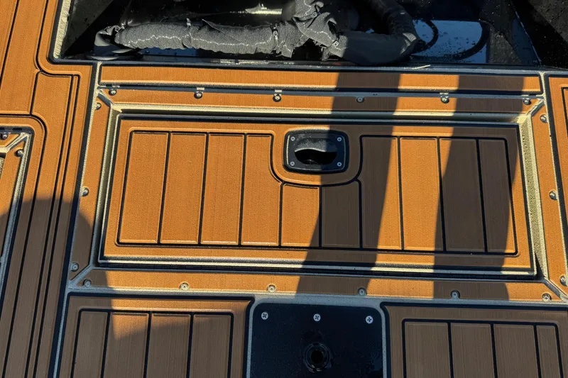 Slide: The Image of 2026 SeaArk Big Easy boat deck with wood finish and storage compartment. - 18