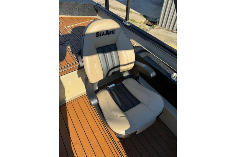 Slide: The Image of 2026 SeaArk Big Easy boat seat with tan and black upholstery on wooden deck. - 27