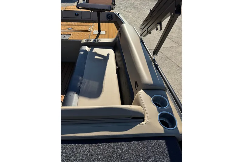 Slide: The Image of 2026 SeaArk Big Easy boat interior with beige seating and cup holders. - 28
